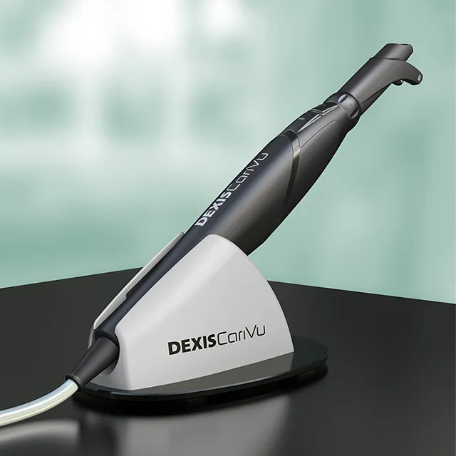 A DEXIS CariVu diagnostic wand resting in its charging base on a dark surface.